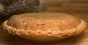 Golden-brown homemade pie on kitchen counter, showcasing a perfectly baked crust.